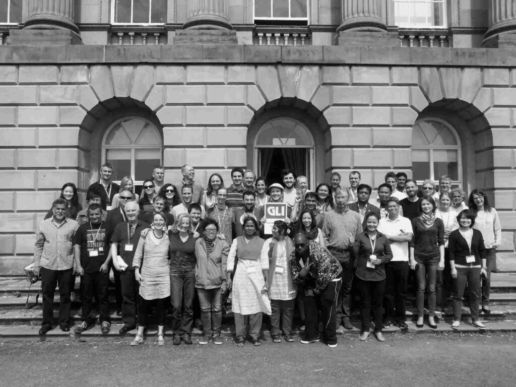 Global Labour Institute Summer School group photo with attendees holding signs